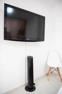 a flat screen tv hanging on a wall with a radiator at Tu Espacio Privado en Medellín E in Medellín