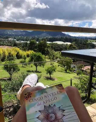 a person is reading a book on a balcony at Alto Paraíso Glamping 