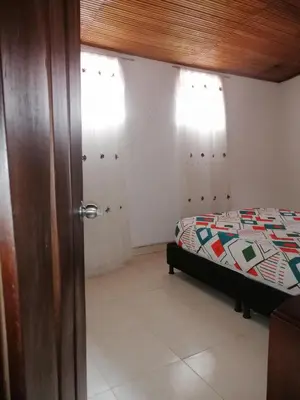 a bedroom with a bed and a wooden door at casa de relajacion lowcost in La Dorada