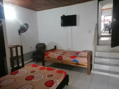 a room with two beds and a tv in it at casa de relajacion lowcost in La Dorada