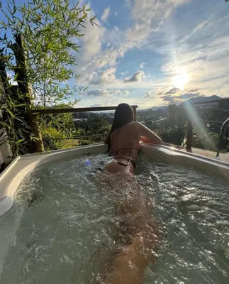 a woman sitting in a jacuzzi in a swimming pool at Alto Paraiso Glamping 
