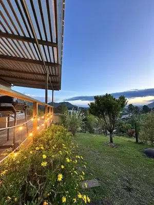 a building with lights on the side of a field at Alto Paraiso Glamping 