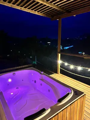 a purple hot tub on a balcony at night at Alto Paraiso Glamping 