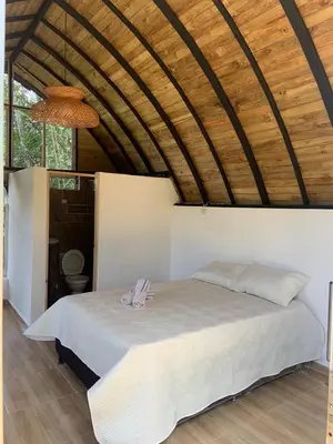 a bed in a room with a wooden ceiling at Glamping A-MAR in Cocorná