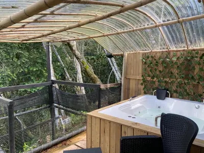 a bathroom with a tub in a greenhouse at Glamping A-MAR in Cocorná