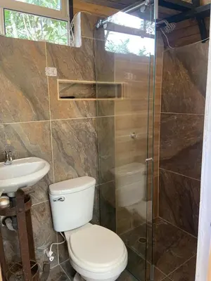 a bathroom with a toilet and a glass shower at Glamping A-MAR in Cocorná