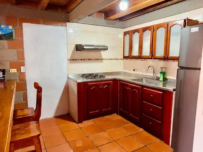 a kitchen with a stove and a sink and a refrigerator at Next to the airport - cute home in Rionegro