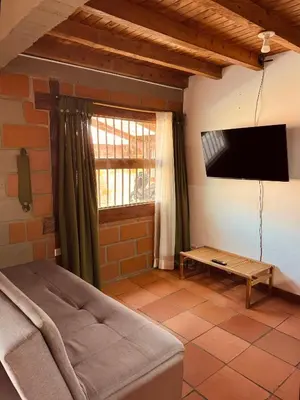 a living room with a bed and a flat screen tv at Next to the airport - cute home in Rionegro