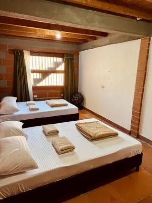 a room with two beds with towels on them at Next to the airport - cute home in Rionegro