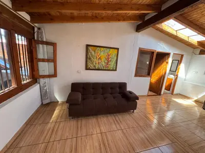 a living room with a couch and a painting on the wall at Next to the airport - cute home in Rionegro