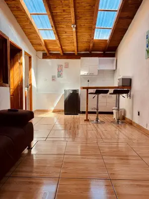 a living room with a wooden floor and a table at Next to the airport - cute home in Rionegro