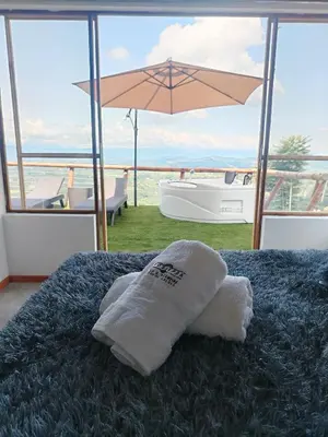 a towel sitting on top of a bed with an umbrella at Glamping Orosierra in Chinchiná