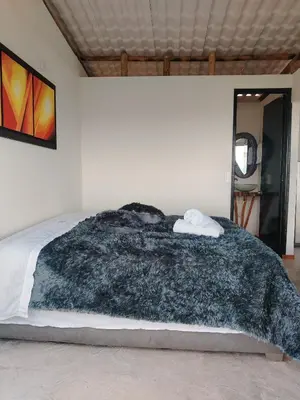 a bedroom with a black blanket on a bed at Glamping Orosierra in Chinchiná