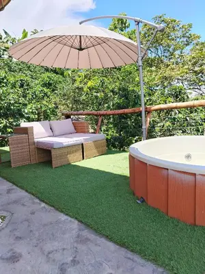 a hot tub and an umbrella with a bench and a hot tub at Glamping Orosierra in Chinchiná