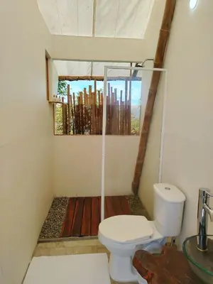 a bathroom with a toilet and a window at Glamping Orosierra in Chinchiná