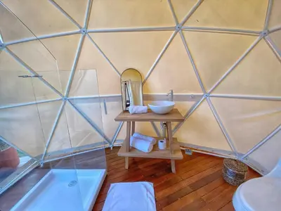 a room with a mirror and a sink in a glass wall at Bohemia Glamping in La Unión