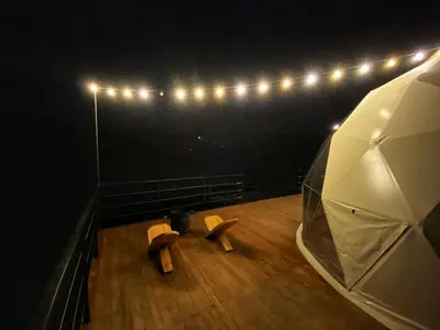 a stage with a bench and lights on a wooden floor at Bohemia Glamping in La Unión