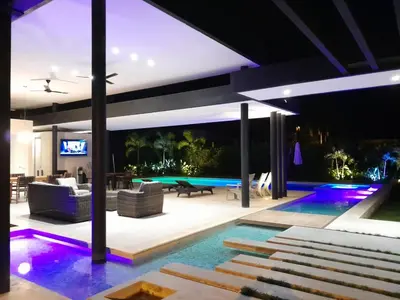 a living room with a swimming pool at night at Finca Luxury (Casa Creta) - Santa fé de Antioquia in Sopetran