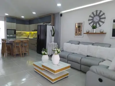 a living room with a couch and a kitchen at ALAMEDA MI DESCANSO in Carmen de Viboral