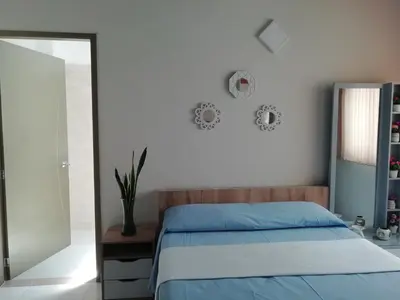 a bedroom with a blue bed and a mirror at ALAMEDA MI DESCANSO in Carmen de Viboral