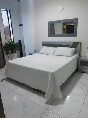 a large white bed in a room with a mirror at ALAMEDA MI DESCANSO in Carmen de Viboral