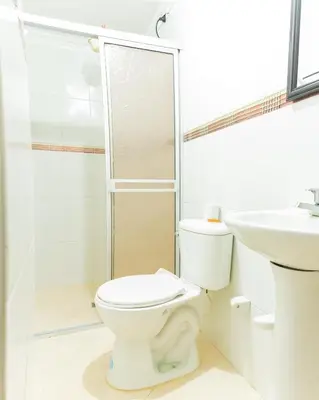 a white bathroom with a toilet and a sink at HOTEL FUENTE DE ORO in Amalfi