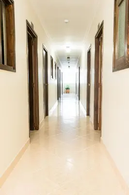 an empty hallway with doors and a tile floor at HOTEL FUENTE DE ORO in Amalfi