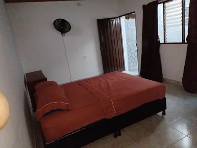 a bedroom with a bed and a fan on the wall at casa la magdalena in La Dorada