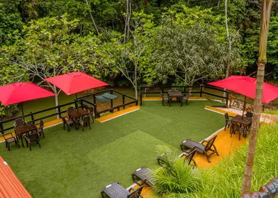 an overhead view of a patio with tables and red umbrellas at Glamping Río Claro in Doradal