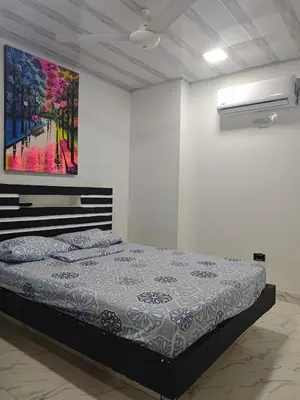 a bedroom with a bed and a painting on the wall at Casa Del Árbol in Doradal