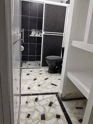 a bathroom with a black toilet and a tile floor at Casa Del Árbol in Doradal