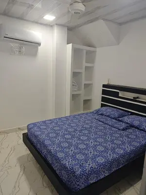 a bedroom with a bed with a blue comforter at Casa Del Árbol in Doradal