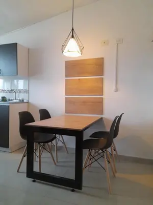 a dining room table with black chairs and a light fixture at Casa Colibrí Hospedaje Manizales a 2 min del Cable y 1 min Zona G in Manizales