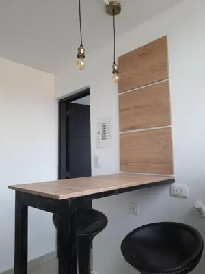 a desk in a room with a black stool at Casa Colibrí Hospedaje Manizales a 2 min del Cable y 1 min Zona G in Manizales