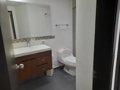 a bathroom with a toilet and a sink and a mirror at Casa Colibrí Hospedaje Manizales a 2 min del Cable y 1 min Zona G in Manizales