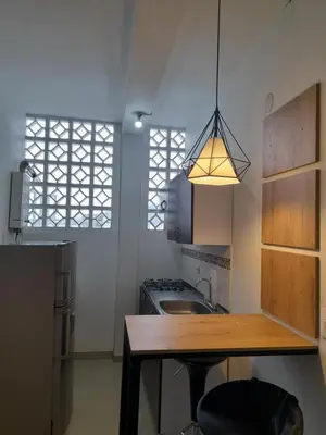 a kitchen with a wooden table and a light fixture at Casa Colibrí Hospedaje Manizales a 2 min del Cable y 1 min Zona G in Manizales