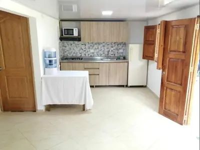a kitchen with a table in the middle of a room at Jardín de la Inmaculada - a 8min del parque in Jardin