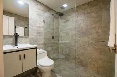 a bathroom with a toilet and a glass shower at First Class Hotel in Medellín