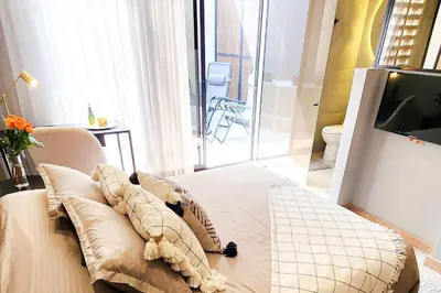 a room with a bed with pillows and a television at Las Lomas Luxury House in Medellín