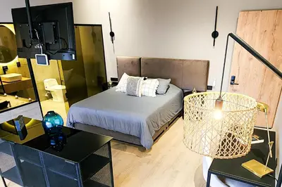a bedroom with a bed and a table and a mirror at Las Lomas Luxury House in Medellín
