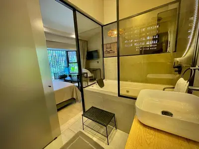 a bathroom with a sink and a tub and a bedroom at Las Lomas Luxury House in Medellín