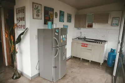 a kitchen with a stainless steel refrigerator and a sink at Cabaña Tierra Verde eje Cafetero in Manizales