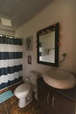 a bathroom with a sink and a toilet and a mirror at Cabaña Tierra Verde eje Cafetero in Manizales