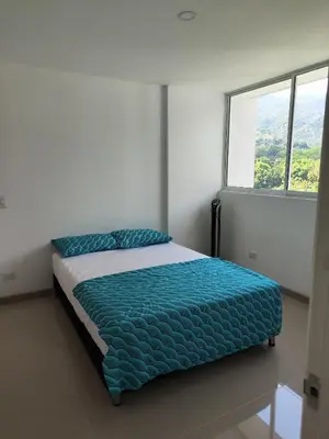 a bed in a white room with a window at Citadela Disole Paraíso in Santa Fe de Antioquia