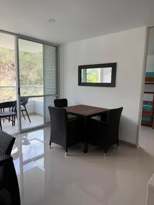 a dining room with a table and chairs and windows at Citadela Disole Paraíso in Santa Fe de Antioquia