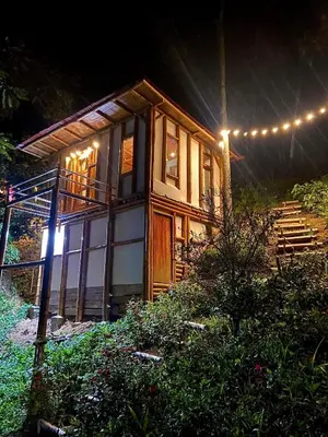 a small wooden house with lights on it at night at Viyamar Glamping: Discover Tranquility in Style in Viterbo
