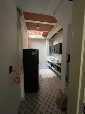 a hallway with a black refrigerator in a kitchen at Apartamento vacacional galeón 2 Doradal in Doradal
