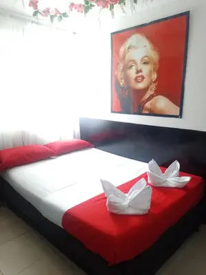 a bedroom with a bed with a picture of a woman at El Amanecer Parque Del Agua in Manizales