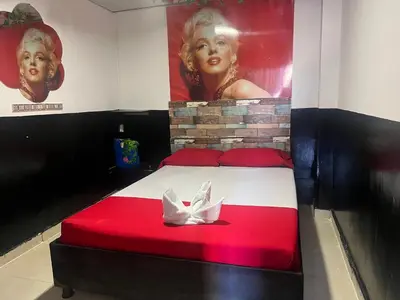 a red and white bed in a room with a painting at El Amanecer Parque Del Agua in Manizales