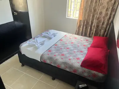 a bedroom with a bed with a red pillow at El Amanecer Parque Del Agua in Manizales